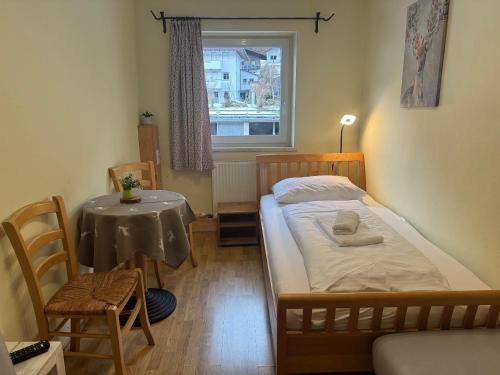 1 dormitorio con cama, mesa y ventana en Auszeit für Singles, Moderne Ferienwohnung im Thierseetal, FeWo 18, en Thiersee