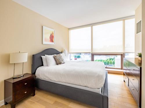 a bedroom with a bed and a large window at Family Friendly Apartment Downtown in Stamford