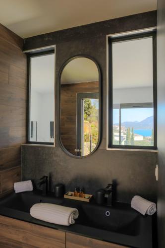 une salle de bain avec un lavabo noir et un miroir dans l'établissement Villa Mare Monti, à Calvi