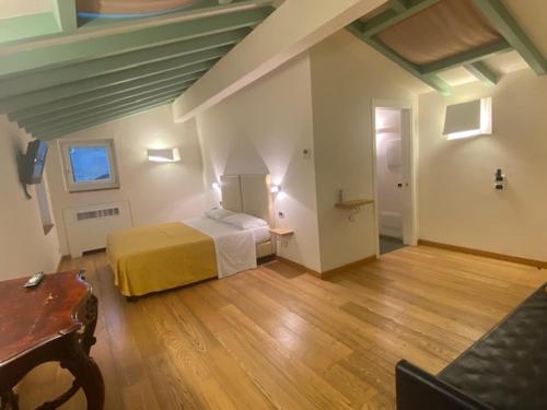1 dormitorio con 1 cama y suelo de madera en Hotel Remàt, en Garda
