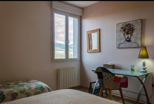 een slaapkamer met een bed, een bureau en een raam bij Terre du Vivant in Cluny