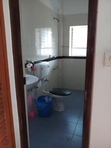 y baño con aseo y lavamanos. en Casa baptista, en Candolim