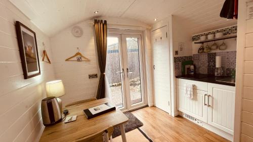 a small kitchen with a table and a window at Hideaway Pod near Loch Ness for a tranquil retreat in Lewiston