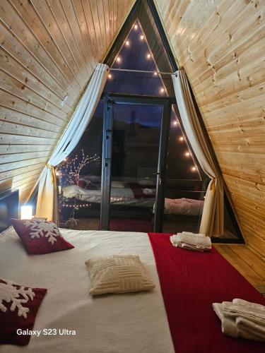 a room with a bed in a tent with a window at Cabana Apuseni Forest 