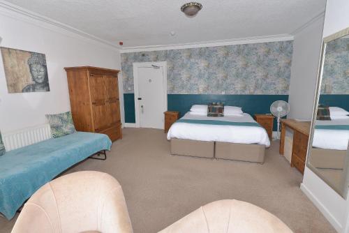 a bedroom with two beds and blue wallpaper at Steeton Hall Hotel & Restaurant in Steeton