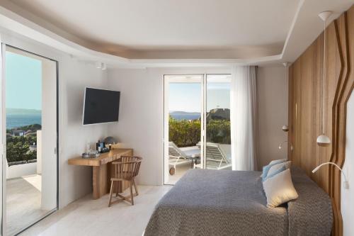 a bedroom with a bed and a view of the ocean at Hotel Grand Relais Dei Nuraghi in Baja Sardinia