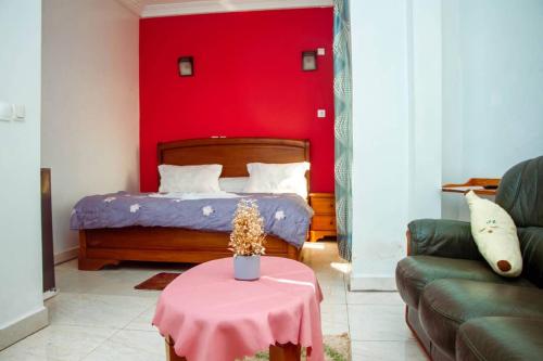 a bedroom with a bed with a red wall at ALICIA HÔTEL in Yaoundé