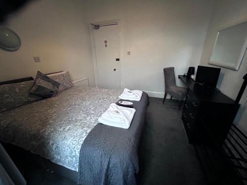 a hotel room with a bed and a desk and a chair at Dunarle Guesthouse in Oban