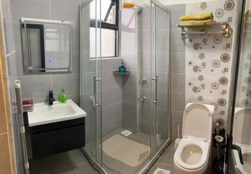 a bathroom with a shower with a toilet and a sink at 1bedroom Exquisite City Apartment in Kilimani by The Manna Stays in Nairobi
