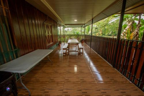 a covered porch with a table and a bench at Chepe's Chic Bungalow in Fortuna