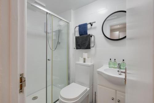 een witte badkamer met een toilet en een douche bij 2 Bedroom Aprtmnt For Upto 6 Nr Centre, Uni &Parks in Cardiff