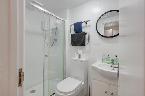 a white bathroom with a toilet and a shower at 2 Bedroom Aprtmnt For Upto 6 Nr Centre, Uni &Parks in Cardiff