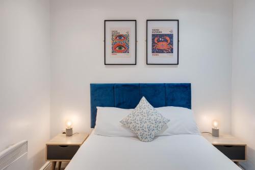 een slaapkamer met een bed met drie foto's aan de muur bij 2 Bedroom Aprtmnt For Upto 6 Nr Centre, Uni &Parks in Cardiff