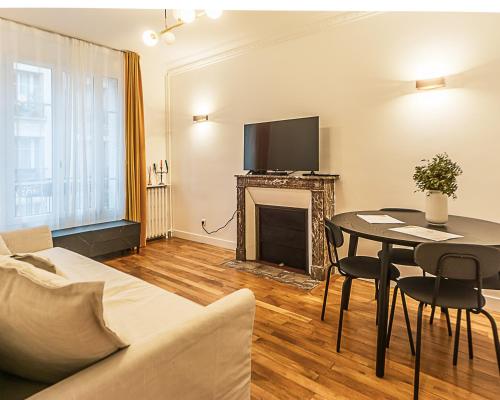 a living room with a couch and a table with a fireplace at The Square, Paris-Asnières, Private Apartment with Bedroom and Living Room in Asnières-sur-Seine