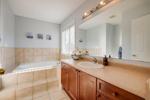 a bathroom with a tub and a sink and a mirror at Tasha Dr Suites, 4BR in Mississauga