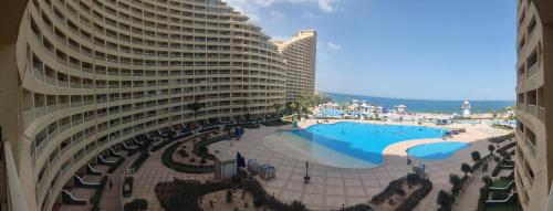 a large building with a swimming pool next to a beach at بورتو السخنه in Ain Sokhna