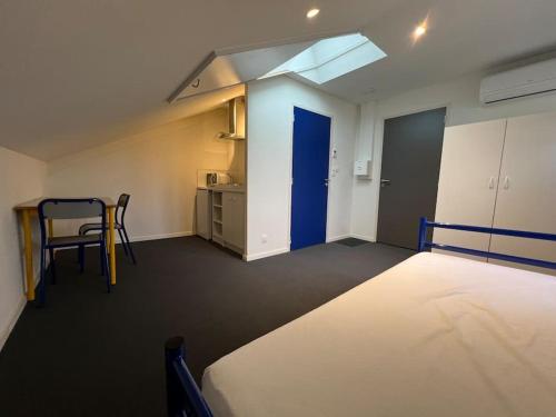 Zimmer mit einem Bett und einem Tisch sowie einer Küche in der Unterkunft Studio 2 - Proche Centre-ville in Paray-le-Monial