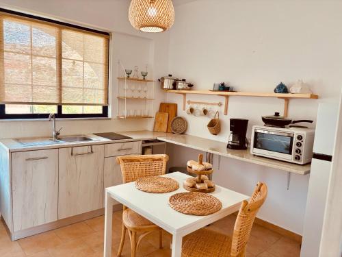 a kitchen with a table and chairs and a microwave at Afroditi Junior Suites in Archangelos