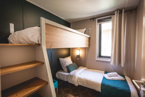 ein kleines Zimmer mit 2 Etagenbetten und einem Fenster in der Unterkunft Les Prairies de la Mer in Grimaud