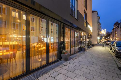 a building with glass windows on a city street at La Mansion Vi Vadi Hotel in Munich