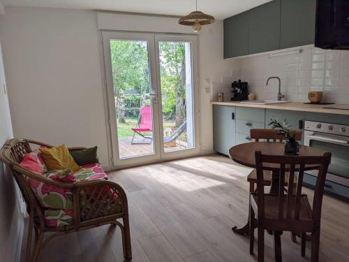 une cuisine avec une table et des chaises ainsi qu'une porte ouverte dans l'établissement Appartement cosy près de Toulouse et du Gers, à Toulouse