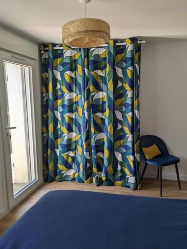 une chambre avec un lit bleu et une fenêtre dans l'établissement Appartement cosy près de Toulouse et du Gers, à Toulouse