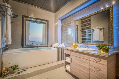 a bathroom with a tub and a sink and a window at Castelli Villa in Lagópodhon