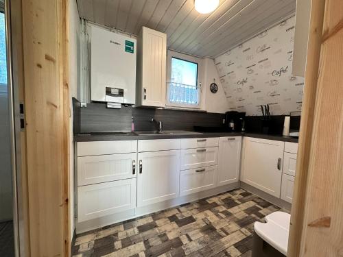 a kitchen with white cabinets and a sink at Finnhütte 7 Mönchgut in Lobbe