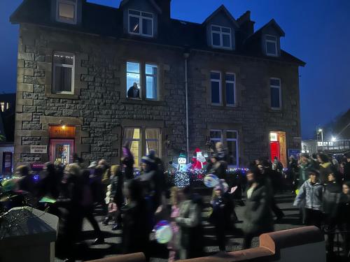 a crowd of people walking in front of a building at Dunarle Guesthouse in Oban