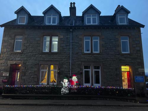 a house with two santa clauses in front of it at Dunarle Guesthouse in Oban