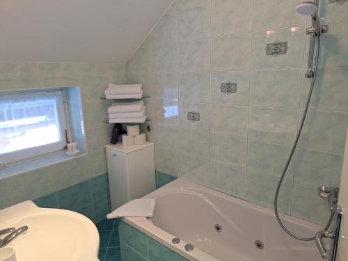 a bathroom with a shower and a tub and a sink at Apartments Mertelj in Kranjska Gora