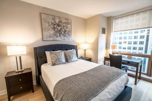 a bedroom with a bed and a desk and a window at Modern Apart Downtown with Indoor Pool in Stamford