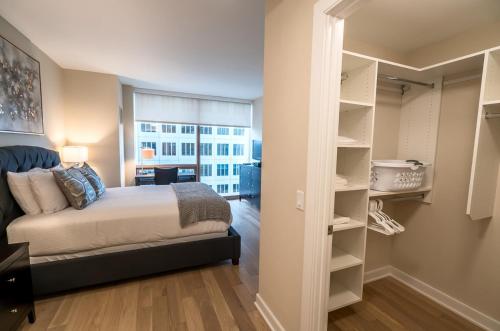 a bedroom with a bed and a closet with a window at Modern Apart Downtown with Indoor Pool in Stamford