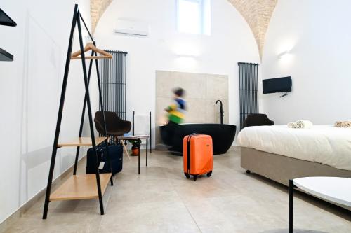 a hotel room with a bed and a suitcase at Suitehome B&B con vasca in Troia