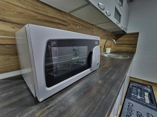 a microwave oven sitting on a counter in a kitchen at Grand Blue 2 Bedroom Apartment Sokobanja in Soko Banja