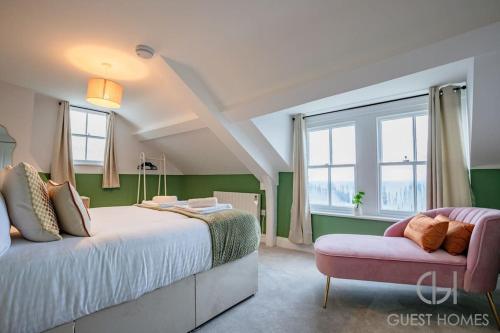 a bedroom with a large bed and a couch at Guest Homes - Foley Abode in Great Malvern