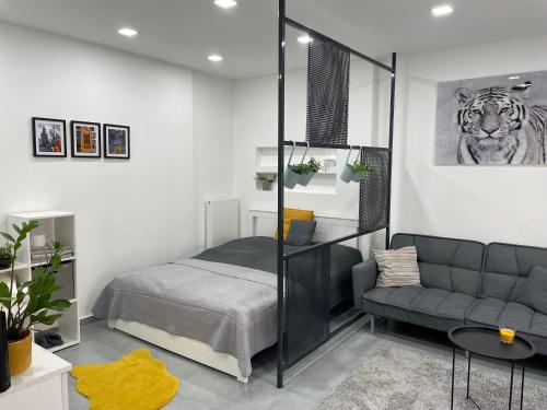 ein Schlafzimmer mit einem Bett und einem Sofa in der Unterkunft London Apartman Szeged in Szeged