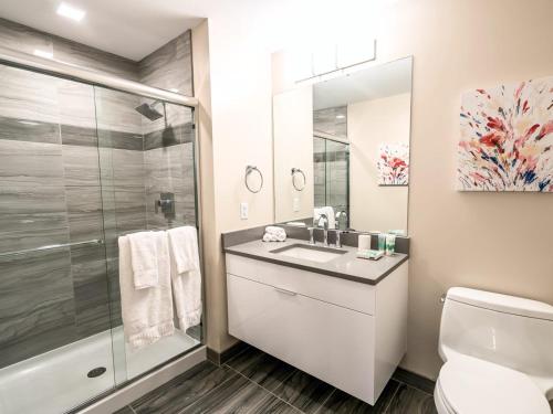 a bathroom with a toilet and a sink and a shower at Spacious Apt Downtown with Gym in Stamford
