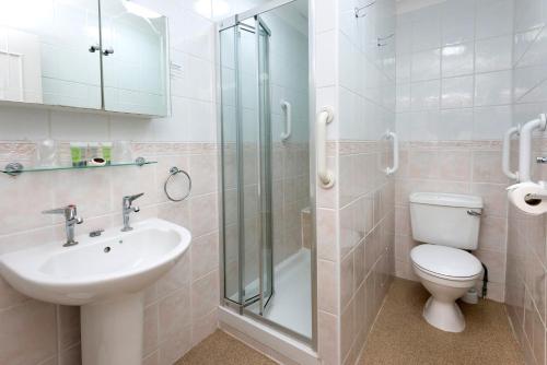 een badkamer met een wastafel, een toilet en een douche bij Royal Norfolk Hotel in Bognor Regis