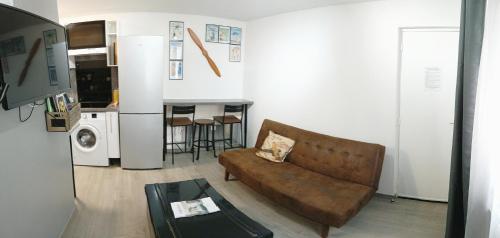een woonkamer met een bank en een tafel bij La Suite du Pilote in La Ferté-Alais