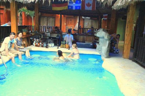 a group of people sitting in a swimming pool at Poshtel Arenal in Fortuna