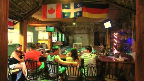 un grupo de personas sentadas en un bar en Poshtel Arenal en Fortuna