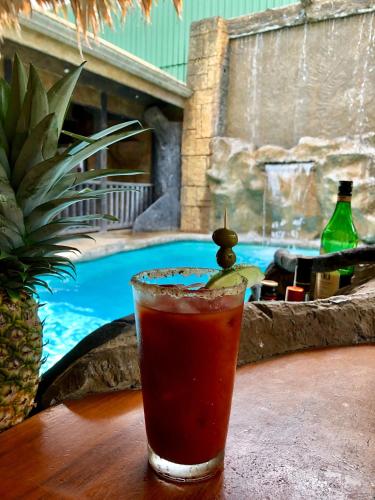 a drink sitting on a table next to a swimming pool at Poshtel Arenal in Fortuna