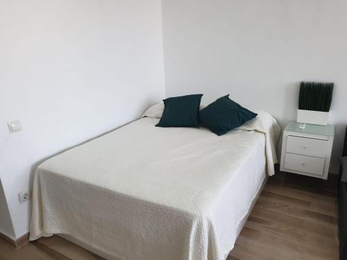 een wit bed met 2 kussens in een kamer bij Acogedor Apartamento 38 verdi7 in Torremolinos