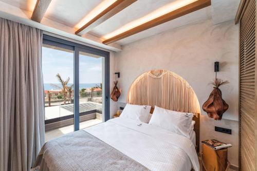 Un dormitorio con una cama y una ventana grande. en Villa Ouranos, en Kiotari