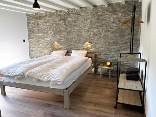 ウッファリーズにあるB&B Le Nid d'Hirondelleのレンガの壁、ベッド付きのベッドルーム1室