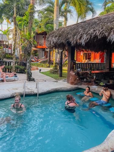 a group of people in a pool at a resort at Poshtel Arenal in Fortuna