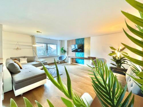 uma sala de estar com um sofá e algumas plantas em 130m2 Loft - Dachterrasse, Netflix, Badewanne, Kaffee em Rosenheim
