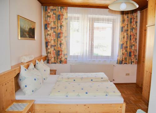 1 dormitorio con 2 camas y ventana en Frühstückspension Kirchenwirt, en Obervellach