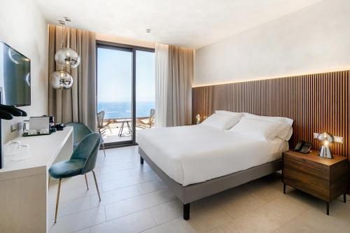a hotel room with a bed and a desk with a chair at Villa Fiorita Boutique Hotel in Taormina